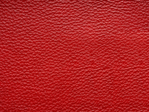 Red quality leather, natural material with design lines pattern or red abstract background. Can use wallpaper or backdrop luxury event, design upholstered furniture, clothing. Genuine leather texture.