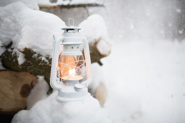 Winter landscape. Cold season. Kerosene lamp or lantern on a snow-white snowy background with...