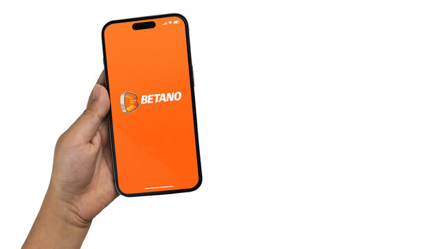 Boy holding a smartphone iPhone 14 Pro with Betano betting provider app on the screen. White background. Rio de Janeiro, RJ, Brazil. November 2022
