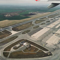 Przelot samolotu nad pasem startowym lotniska - obrazy, fototapety, plakaty