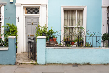 Colorful entrance to the old house with flower pots and open gate, spring time in London, UK, Europe