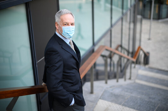 Mature business man portrait outdoor wearing a protective mask against covid 19 coronavirus pandemic