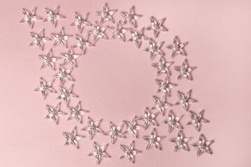 Transparent stars on a pastel pink background. Flat lay, top view, copy space.