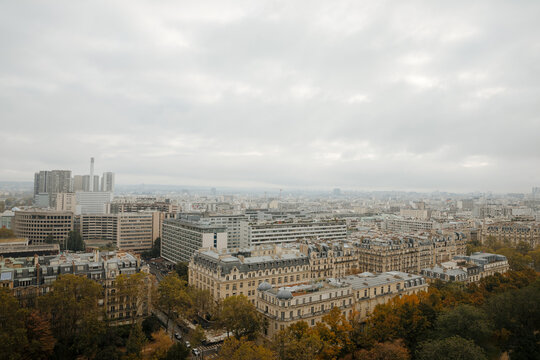 Top view of a European country with lots of green trees and buildings. Image of Paris from above. French state in autumn