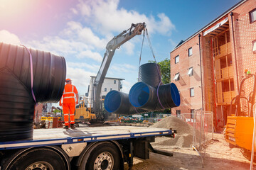 Attenuation tank made of big diameter plastic pipe delivered on construction site by truck and...