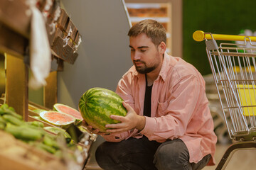 Fototapeta premium the guy makes purchases in the supermarket, the concept of shopping