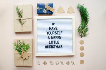 Christmas flatlay letter board spelling Have yourself a merry little Christmas with decorations and wrapped gifts. Holiday card, Christmas greetings concept.