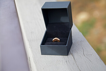 Diamond Ring in a Box sitting on a Railing Outdoors