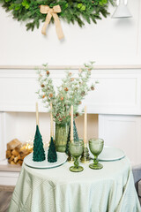 The table is set near the Christmas tree for a romantic New Year's dinner. New Year's festive dinner.