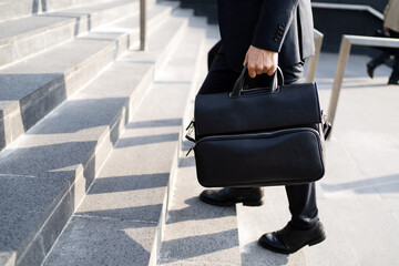 A businessman goes to the office with a briefcase in his hands