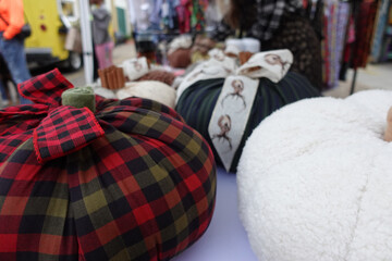 Close-up of stuffed fabric, poly-fil pumpkins on a table at a craft market in the fall