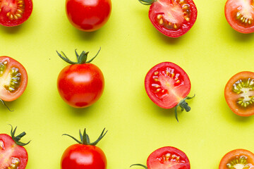 Fresh tomatoes, whole and half cut isolated on green background.