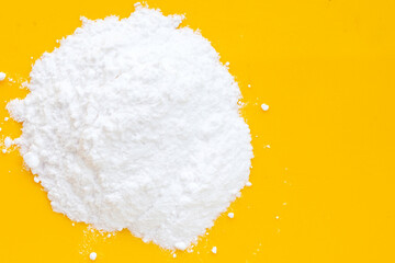 Baking soda on yellow background.