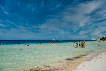 Group of people standin in the water beach on a sunny day in Cancun, Yukatan, Mexico