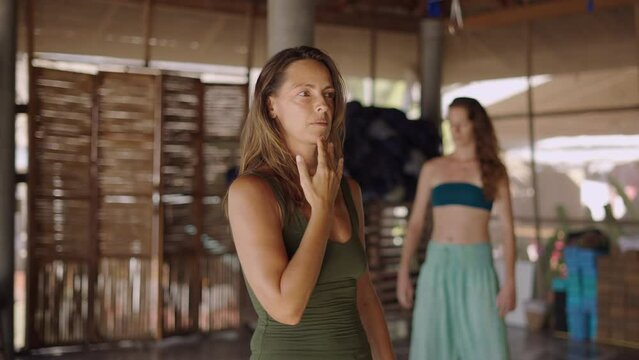 Cheerful woman talking to her yoga class in healing center in Thailand - slow motion shot 