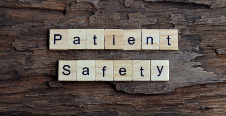 Patient Safety word written on wood block Patient Safety text on wooden table , Top view 
