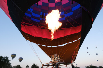 Obraz premium A view inside a hot air balloon with more balloons in the distance