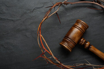 Crown of thorns and judge gavel on black table, flat lay. Space for text