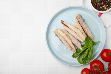 Canned mackerel fillets served on white tiled table, flat lay. Space for text