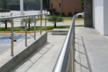 Concrete ramp with metal handrail near building outdoors, closeup