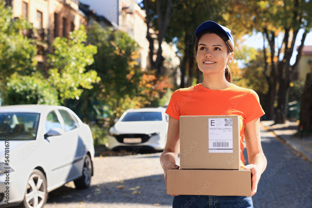 Poster Courier carrying cardboard boxes on city street