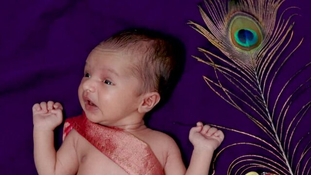 newborn baby boy in krishna dressed sneezing expression from top angle