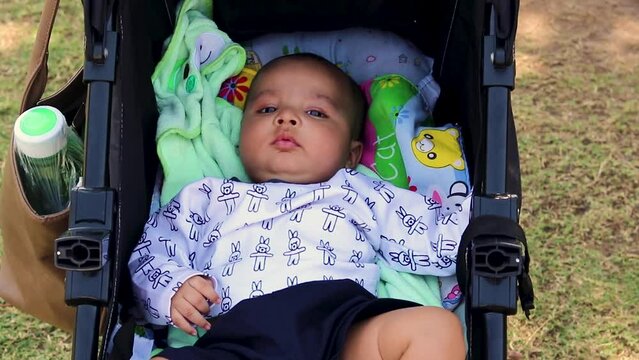 cute baby boy playing at stroller seat from flat angle