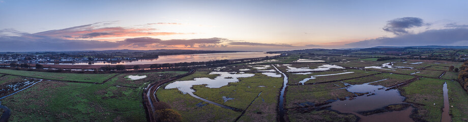 Sunrise over Wetlands and meadows in RSPB Exminster and Powderham Marshe from a drone, Exeter, Devon, England