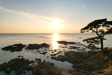 Fototapeta na wymiar 海面にうつる夕日と日本の海岸