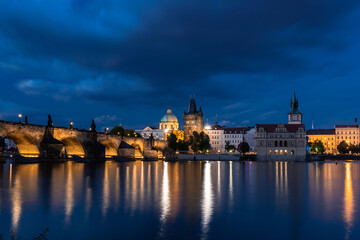 Fototapeta na wymiar Charles Bridge during blue hour lit by yellow street lights, Prague, Czech Republic