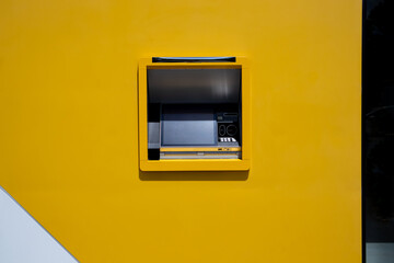 Automated teller machine ATM. Yellow cash dispenser. Withdraw money in bank.