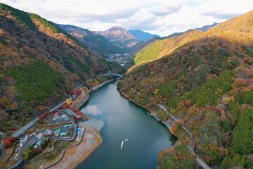 Fototapeta premium 紅葉する山に囲まれた湖と雲