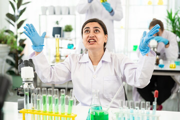 woman working at scientist laboratory bored. Lazy sleepy scientist stretching her arms, she is...