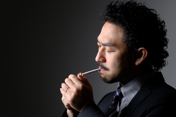 煙草を吸うダンディな男性の横顔　タバコに火をつける