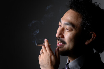煙草を吸うダンディな男性の横顔 アップ