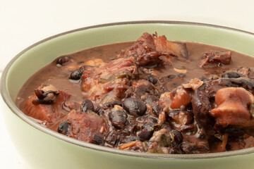 Brazilian feijoada on green plate.