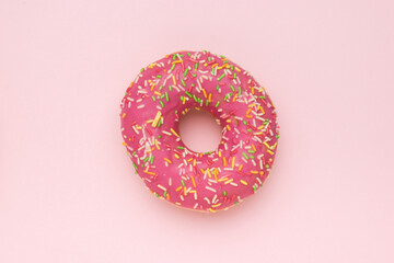 Bright red glazed donut on a pink background. The minimal concept of popular baking.