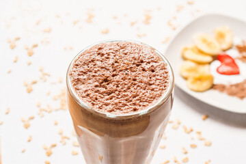 Banana smoothie with chocolate on a white base with oatmeal.