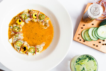 Chili water, saucer and ingredients on a board on a white background.