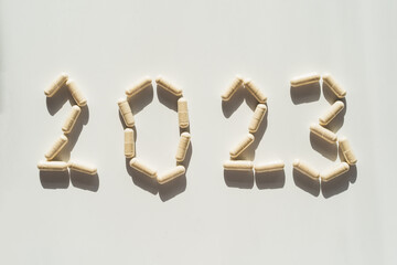 Vitamins on a white background. White Capsules form the new year 2023. Concept of health and new...