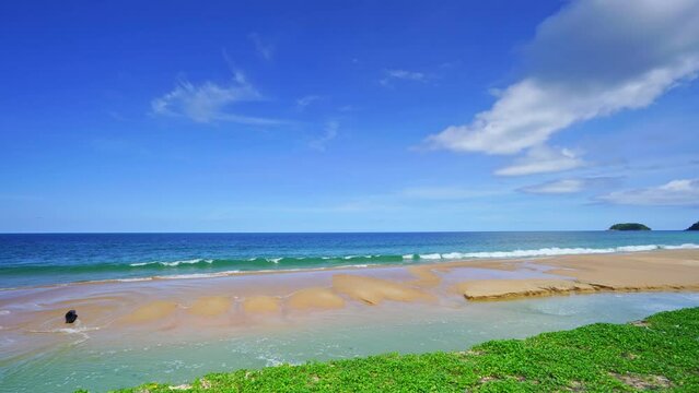 Summer sea background.Blue sky white clouds over ocean waves break on sand beach.Waves crashing against an empty beach.Sea waves and beautiful sand beach in Patong Phuket Thailand. High quality video