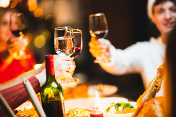 Glasses of champagne and wine in hands of people at party. happy friends or family having christmas dinner at home.