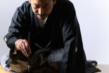 Japanese man who looks like a calligrapher(shodo) doing calligraphy - obrazy, fototapety, plakaty
