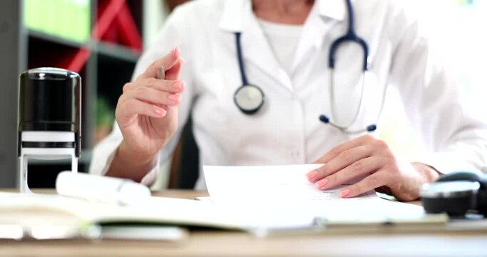 Hand of internist doctor using medical stamp on prescription paper in office