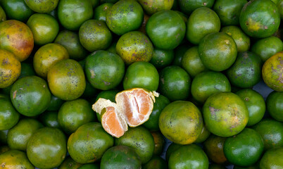 A pile of green oranges in the supermarket