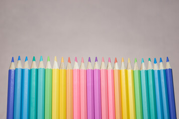 Group of color pencild laying in row striaght line made by pencil tips with grey background close up, Color pancils, copy space, Pastel color concept, Background concept, Education concept.
