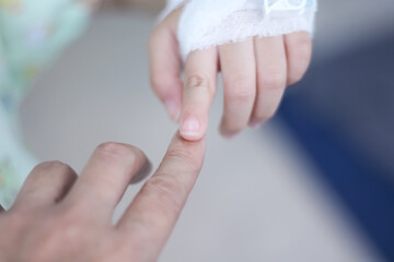 Asian child girl  index finger  with white gauze bandage wound and collided on mother hand