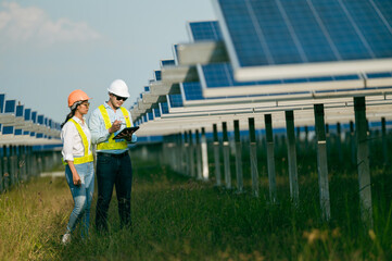 Asian Young Inspector Engineer man and female colleague checking operation in solar farm