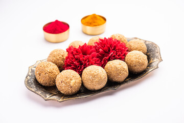 tilgul or til gul laddu or Sesame seed jaggery ball or til ke laddo with flower and haldu kumkum