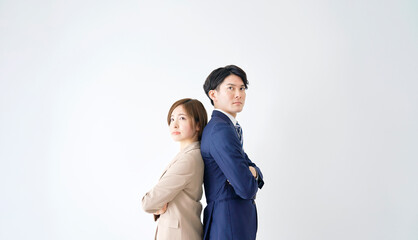 腕組みをするビジネスウーマンとビジネスマンのポートレート　白背景　コピースペースあり